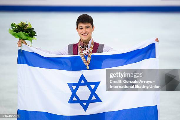 Daniel Samohin from Israel poses with his falg and his gold medal after winning the Final Men's during the Men's program of the ISU World Junior...