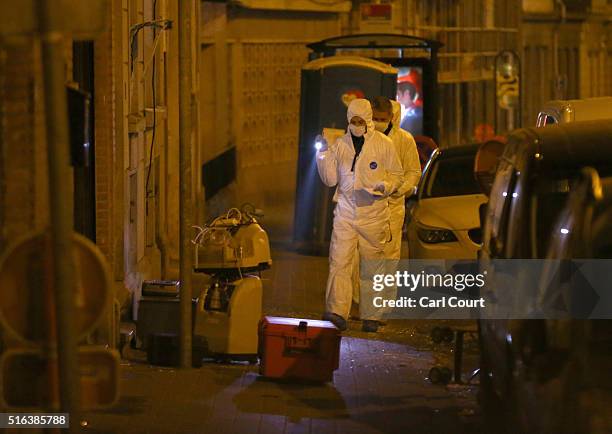 Forensic police investigate outside the building where raids took place in which several people, including Paris attacks suspect Salah Abdeslam, were...