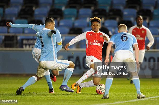 Reiss Nelson of Arsenal takes on Cameron Humphreys-Grant and Jacob Davenport of Man City closes in during the match between Manchester City and...