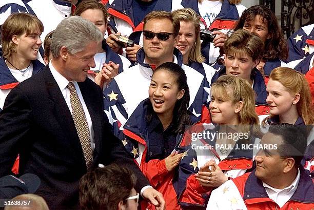 President Bill Clinton walks past US Olympic figure skaters Michelle Kwan , Tara Lipinski , and Jenni Meno on his way into to a ceremony to welcome...