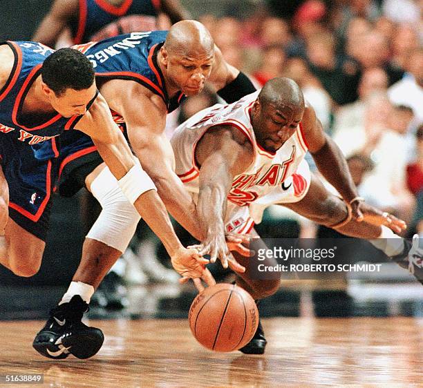 Voshon Lenard of the Miami Heat, and Terry Cummings and John Starks of the New York Knicks lunge for a loose ball in the first quarter of the fifth...