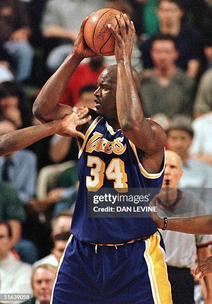 Lakers player Shaquille O'Neal is hand-checked by two Seattle SuperSonics during the Western Conference play-off game 12 May in Seattle. O'Neal had...