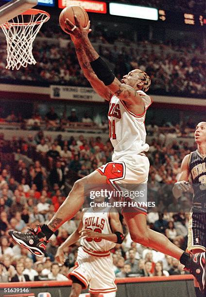 Dennis Rodman of the Chicago Bulls drives to the basket by Reggie Miller of the Indiana Pacers 17 May during the first half of game one of their NBA...