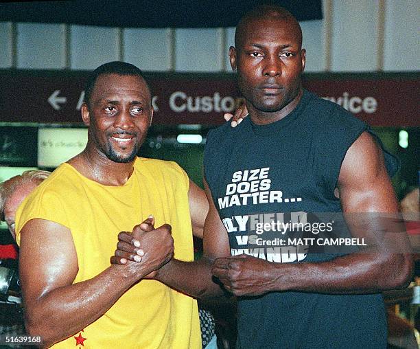 Heavyweight boxer Henry Akinwande of Great Britain and six-time-champion Tommy Hearns of the US pose for photographers 18 May inside Penn Station in...
