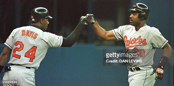 Baltimore Orioles' Joe Carter is met by teammate Eric Davis after Carter hit a second inning home run against the Seattle Mariners 26 May in Seattle,...