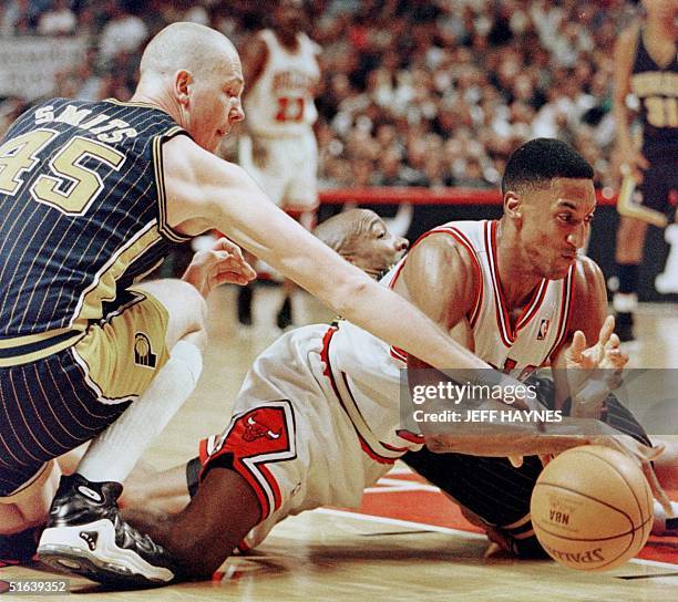 Scottie Pippen of the Chicago Bulls scrambles for a loose ball with Rik Smits of the Indiana Pacers 27 May during the first half of game five of...