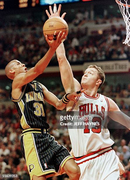 Luc Longley of the Chicago Bulls blocks the shot of Reggie Miller of the Indiana Pacers 27 May during the first half of game five of the NBA Eastern...