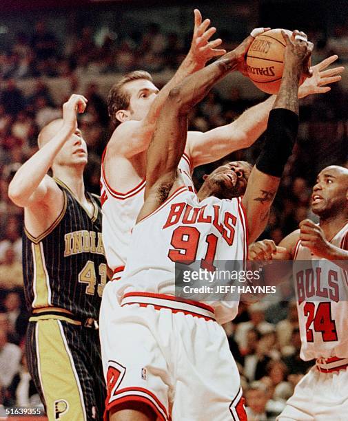 Dennis Rodman of the Chicago Bulls grabs a rebound away from teammate Bill Wennington and Scott Burrell along with Mark Pope of the Indiana Pacers 27...
