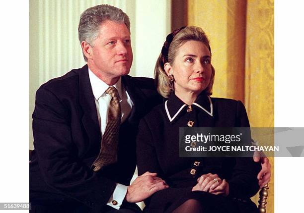 President Bill Clinton and his wife Hillary listen to speakers at a Coalition for America's Children event at the White House in Washington, DC 03...