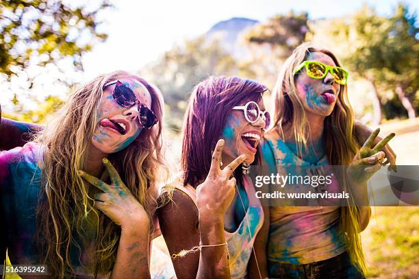 multi-ethnic group of girls celebrating holi festival - holi hands stock pictures, royalty-free photos & images