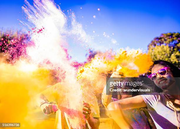 multi-ethnic group celebrating holi festival in park - throwing stock pictures, royalty-free photos & images