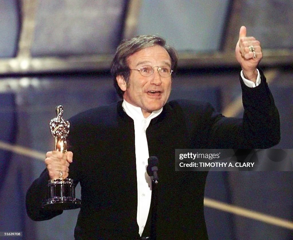 Actor Robin Williams holds up his Oscar after winn