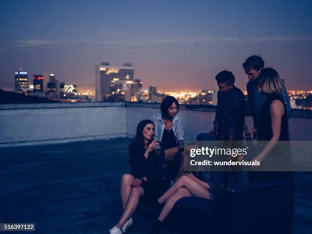 hipster freunde trinken und reden auf einer partei auf dem dach - rooftop stock-fotos und bilder