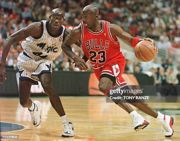 Chicago Bulls guard Michael Jordan drives past Orlando Magic forward Charles Outlaw for two points during the first period of the game at the Arena...