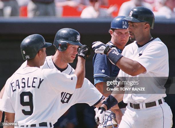 Detroit Tigers' first baseman Tony Clark is congratulated by Tigers' outfielder Luis Gonzalez and second baseman Damion Easley after hitting a...