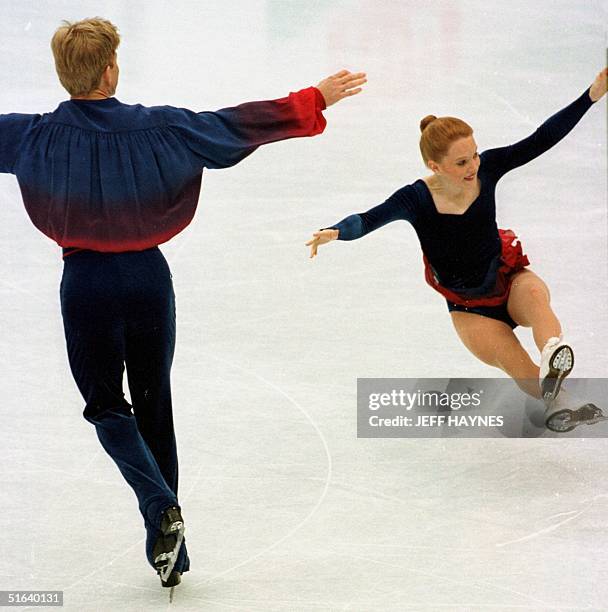 Todd Sand of the US watches as partner Jenni Meno falls during a toss triple during the pairs free program 01 April at World Figure Skating...