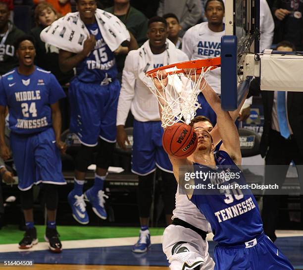 Middle Tennesee STate's Reggie Upshaw dunks against Michigan State's Colby Wollenman in the first half during the first round of the NCAA Tournamet...