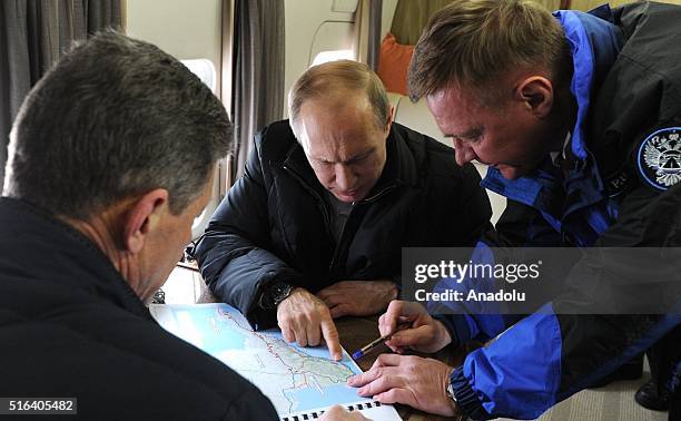 Russia's president Vladimir Putin , deputy prime minister Dmitry Kozak , and the head of Russia's Federal Road Agency , Roman Starovoit look at a map...