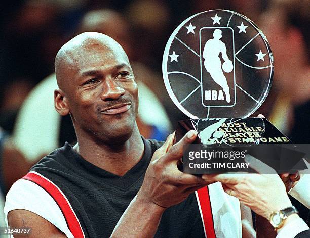 Chicago Bulls' Michael Jordan holds up the Most Valuable Player trophy which he earned in leading the Eastern Conference to victory in the NBA...