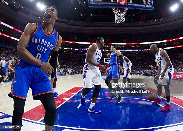 Russell Westbrook of the Oklahoma City Thunder reacts after a dunk against Elton Brand and Carl Landry of the Philadelphia 76ers on March 18, 2016 at...