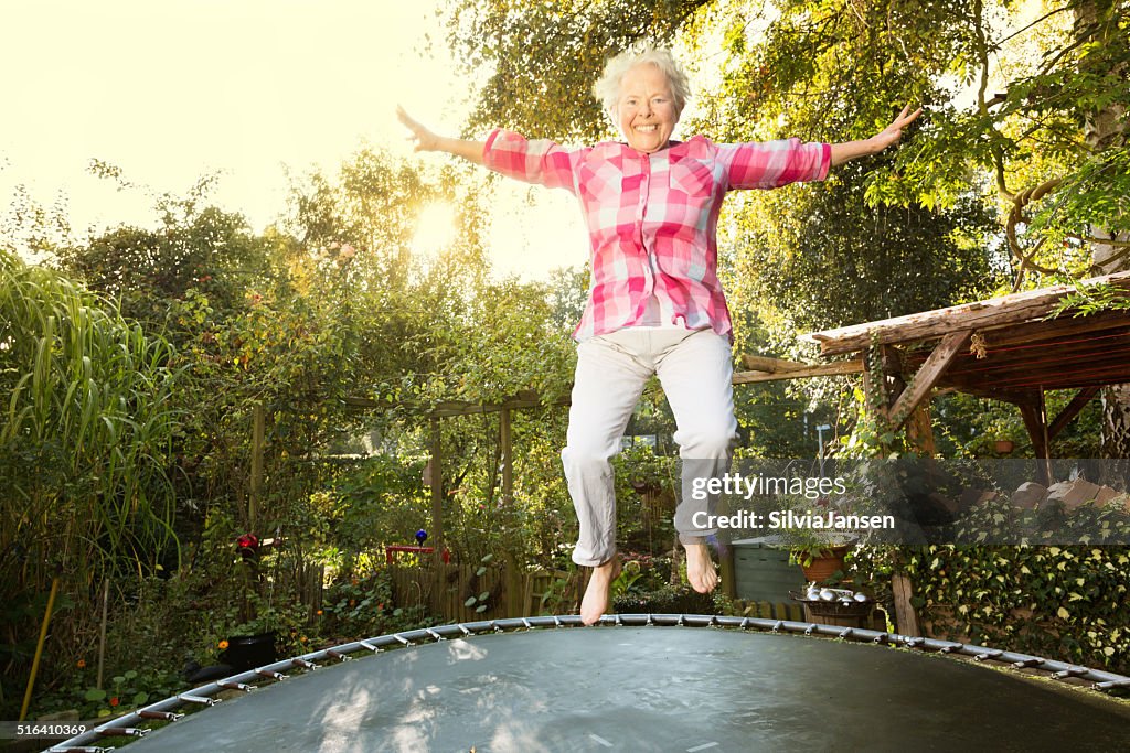 Allegro donna sovrappeso senior saltando sul Trampolino elastico