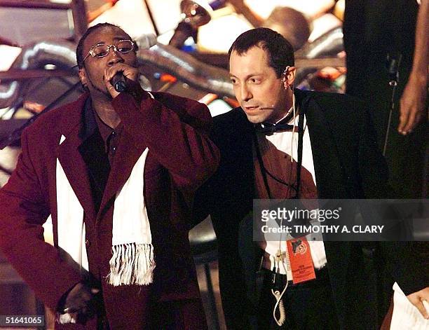 Unidentified member of the group Wu Tang Clan is taken off the stage after jumping on the stage and taking the microphone as the Grammy was about to...