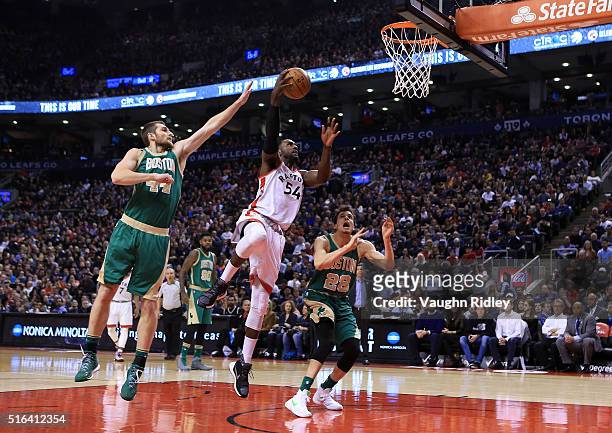 Patrick Patterson of the Toronto Raptors shoots the ball as Tyler Zeller of the Boston Celtics defends during the first half of an NBA game at the...