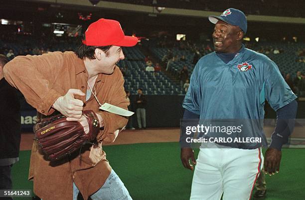 Actor John Cusack shows Toronto Blue Jay hitting coach Gary Matthews his style during batting practice before a spring training game against the St....