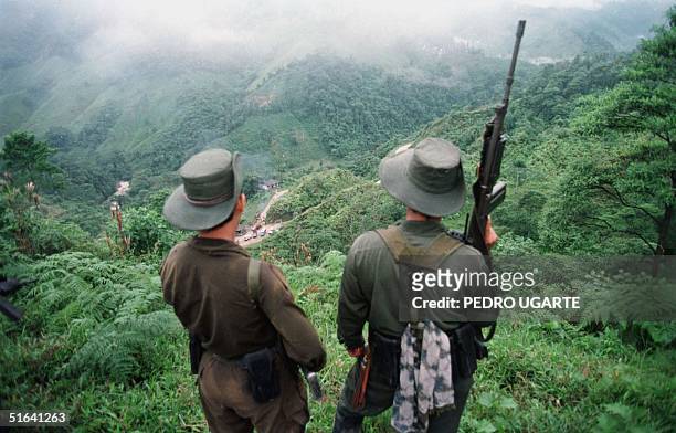 Two armed soldiers belonging to the Revolutionry Armed Forces of Colombia monitor the Berlin pass, 07 March, near Florencia, in the southern Caqueta...