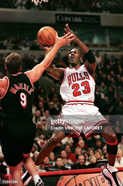 Michael Jordan , guard for the Chicago Bulls, drives to the basket as he is covered by Dan Majerle, guard for the Miami Heat, during the first...