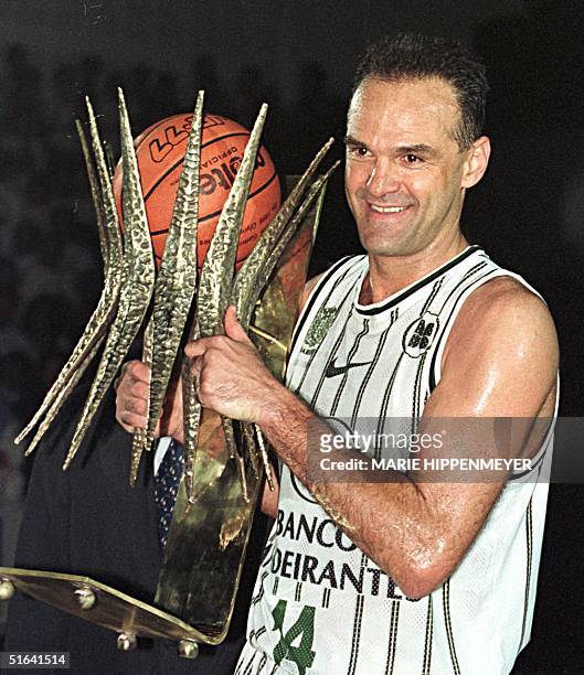 Brazilian basketball player Oscar Schmidt holds a trophy 15 March in Barueri, Brazil for his 22 years of professional play. El astro del basquetbol...