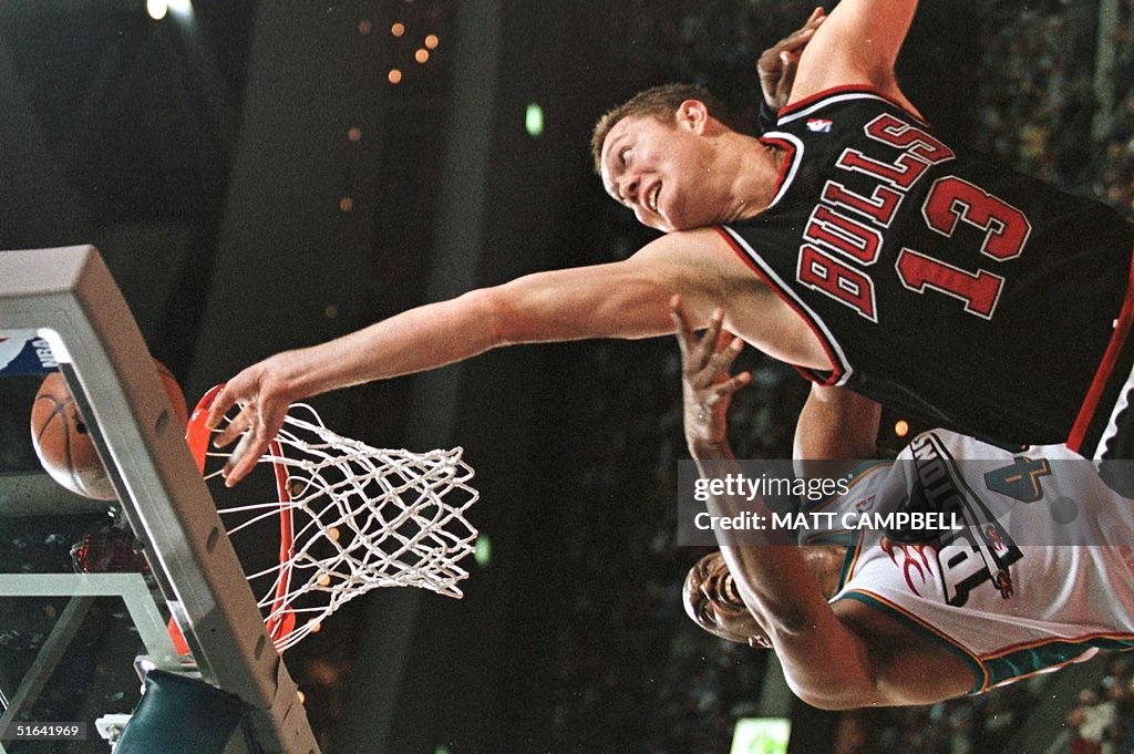 The Chicago Bulls' Luc Longley (R) tips the ball i