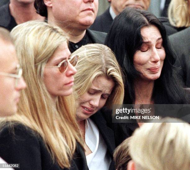 Entertainer Cher , her daughter Chastity and Mary Bono , the widow of Sonny Bono, mourn as Bono's casket is placed inside the hearse after a Catholic...