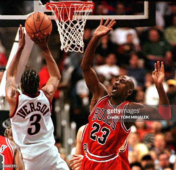Chicago Bulls Michael Jordan reacts as Philadelphia 76ers Allen Iverson goes up to the basket for two points in the game 15 January in Philadelphia,...