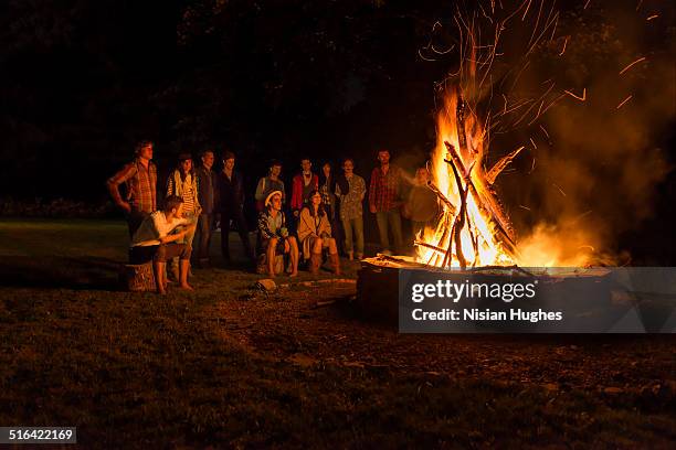 group of people around bonfire - bon fire foto e immagini stock