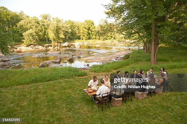 friends eating at an outdoor dinner party - large group of people eating stock pictures, royalty-free photos & images