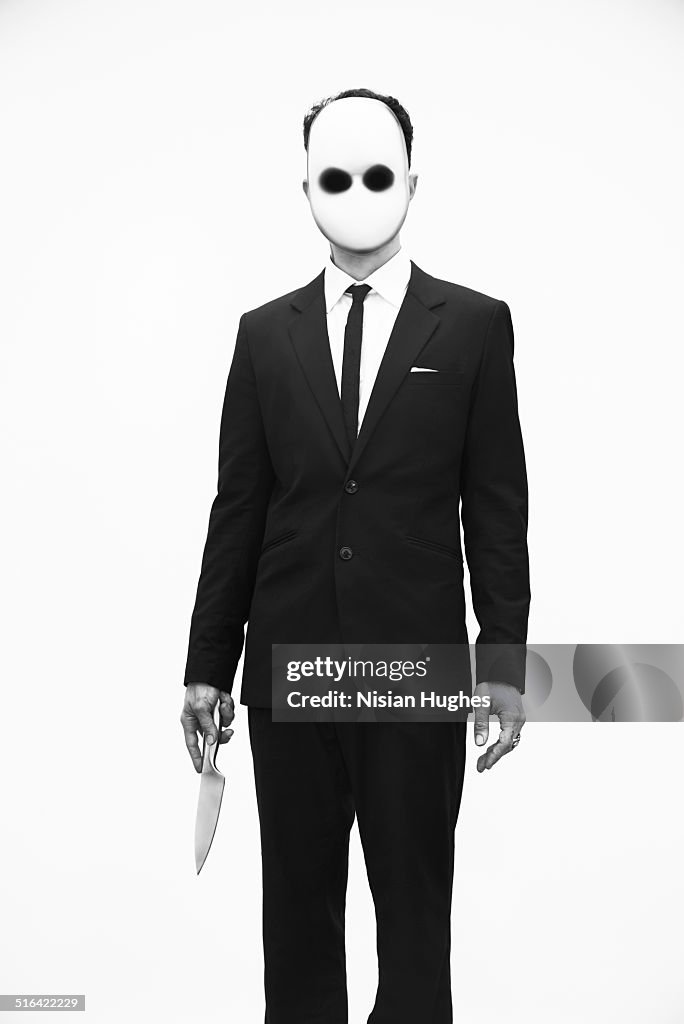 Portrait of man with mask on and knife in hand