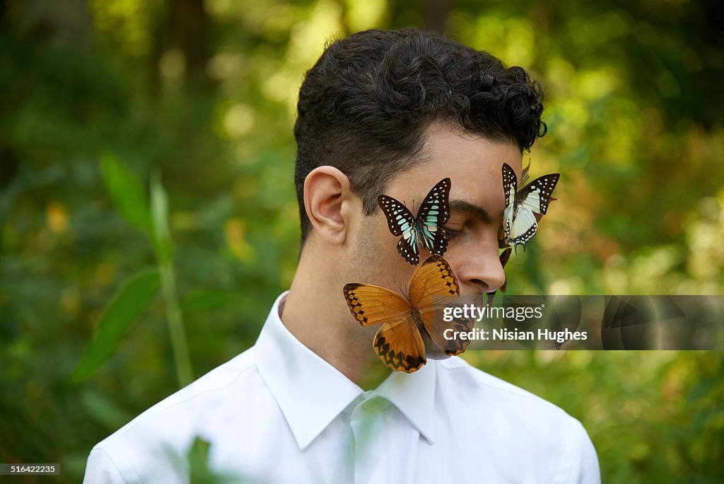 Portrait of man with butterflies on his face