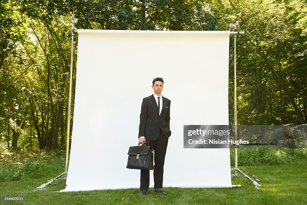 Business man on backdrop in nature