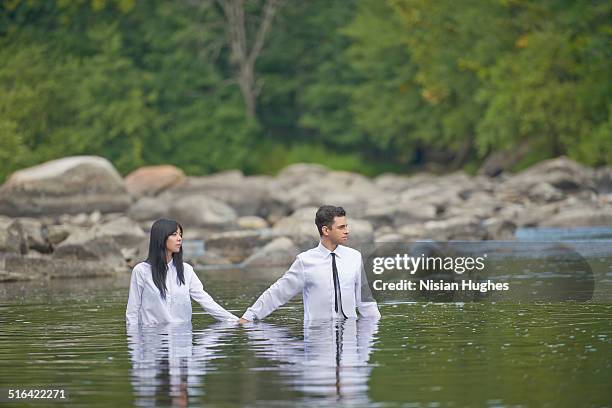 couple holding hands walking in water - wade bildbanksfoton och bilder