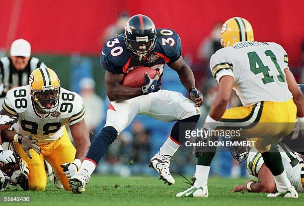 Denver Broncos running back Terrell Davis runs between Green Bay Packers defenders Gabe Wilkins and Eugene Robinson in the first quarter of Super...