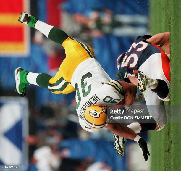 Green Bay Packers fullback William Henderson is upended by Denver Broncos defender Bill Romanowski during first half action at Super Bowl XXXII in...