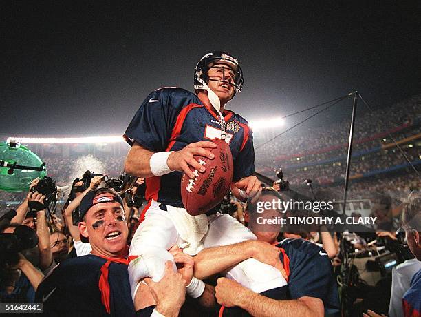 Denver Broncos quarterback John Elway is carried by teammates Ed McCaffrey and Bubby Brister after the Broncos defeated the Green Bay Packers 31-24...