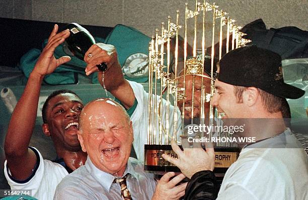 Florida Marlins player Edgar Renteria , Gary Sheffield , and Tony Saunders celebrate their 3-2 win in game seven of the World Series with owner Wayne...