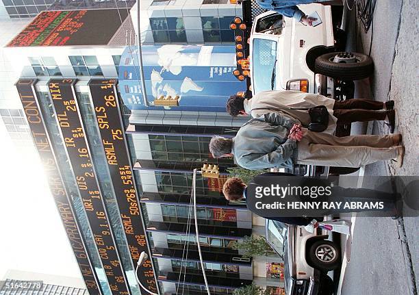 Pedestrians on Broadway in Manhattan look up at a stock market ticker on the outside of Morgan Stanley, in New York, 28 October. Stocks rallied and...