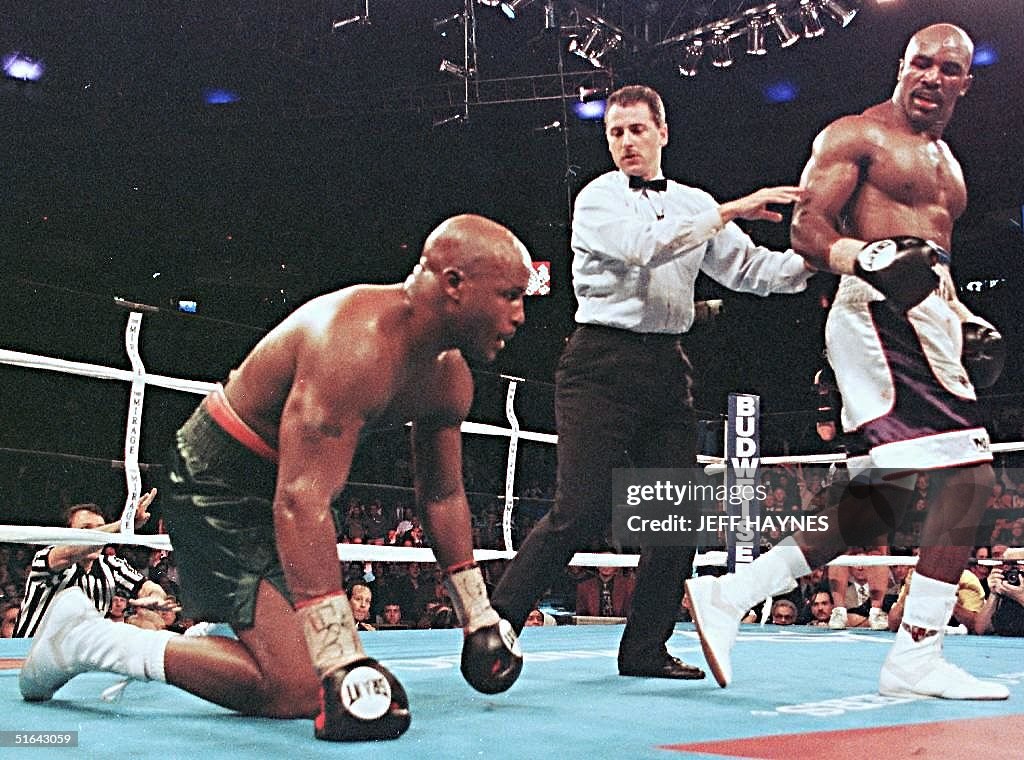 Holyfield Ripped Evander Holyfield walks away after knocking down Michael Moorer in ...