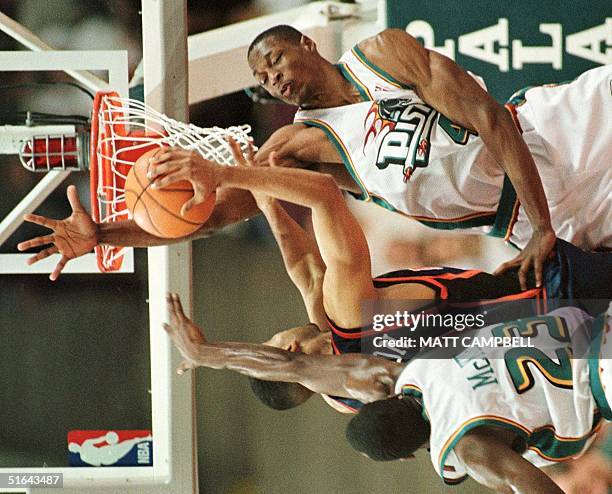 The New York Knicks' Allan Houston is caught between by the Detroit Pistons' Aaron McKie and Theo Ratliff in the third quarter of their game 28...