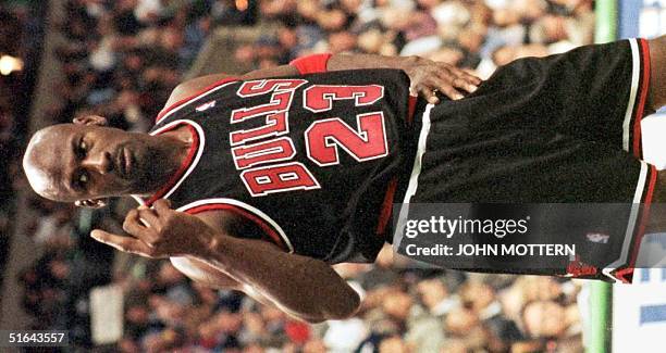 During a break in play, Michael Jordan of the Chicago Bulls motions to a jeering Boston Celtics fan to come down and join him on the court during the...
