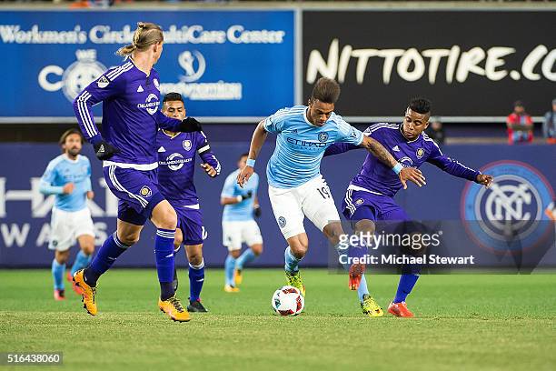 Forward Khiry Shelton of New York City FC tries to push the ball past Orlando City SC players Brek Shea and Seb Hines during the Orlando City SC vs...