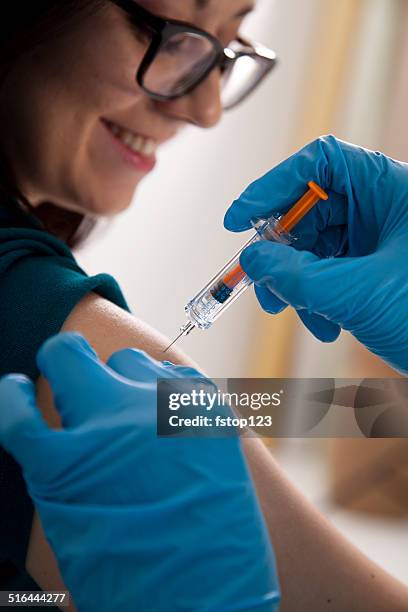 medical: nurse at pharmacy clinic giving flu shot to patient. - flu vaccination stock pictures, royalty-free photos & images